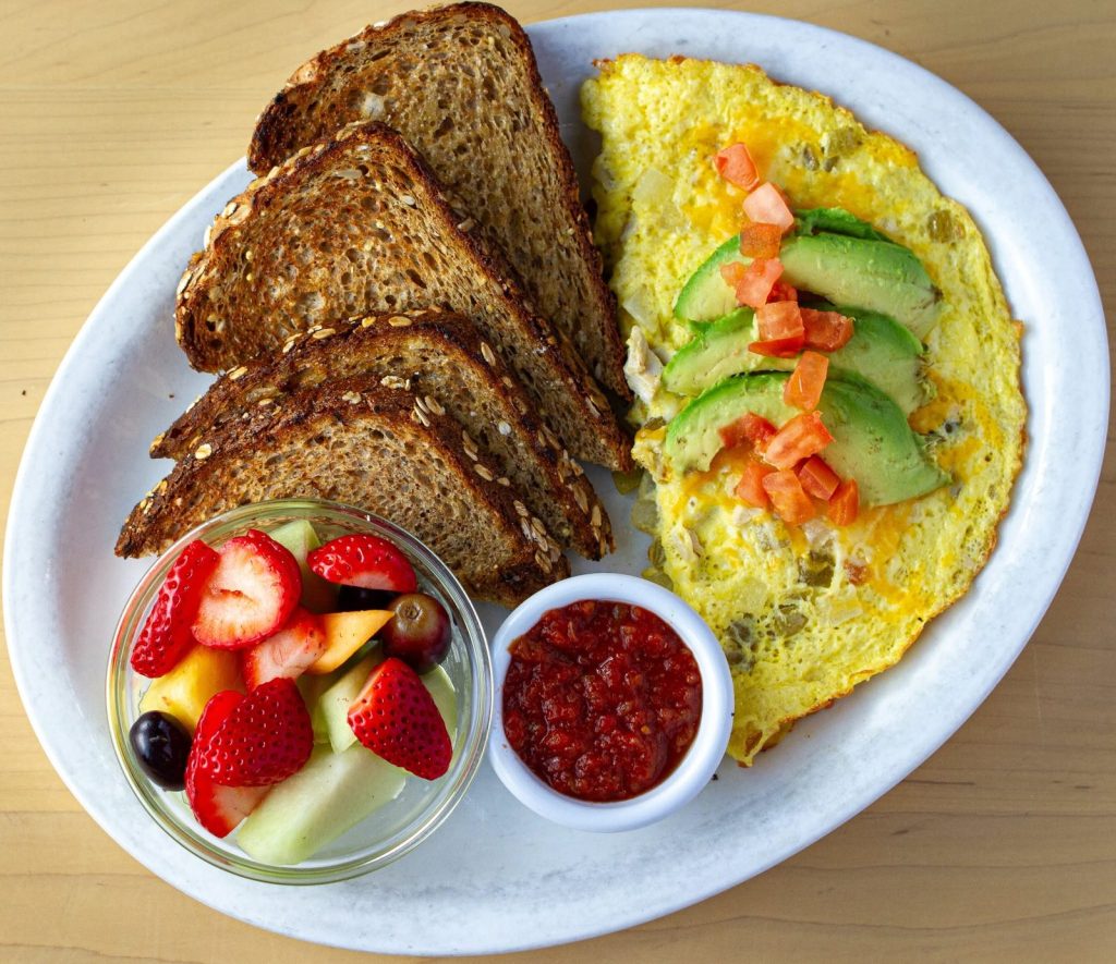 Omelette with avocado, wheat toast and fresh fruit from the Valparaiso breakfast menu at Le Peep